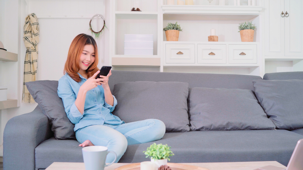 Woman using her smartphone while on the couch