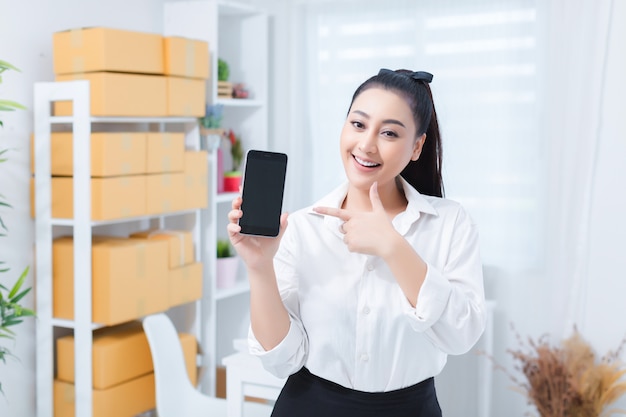 a business woman does a small business at home and holding her phone