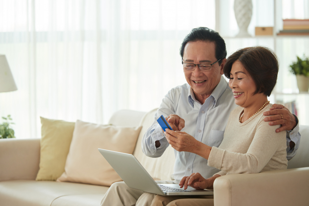 Elderly couple using their card to pay