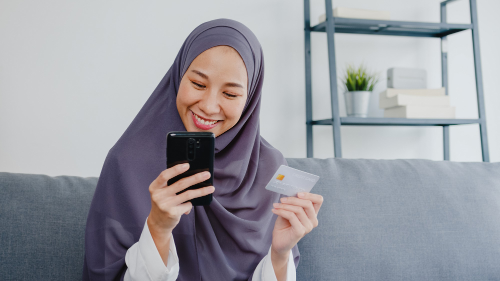 Woman using her card and smatphone to pay