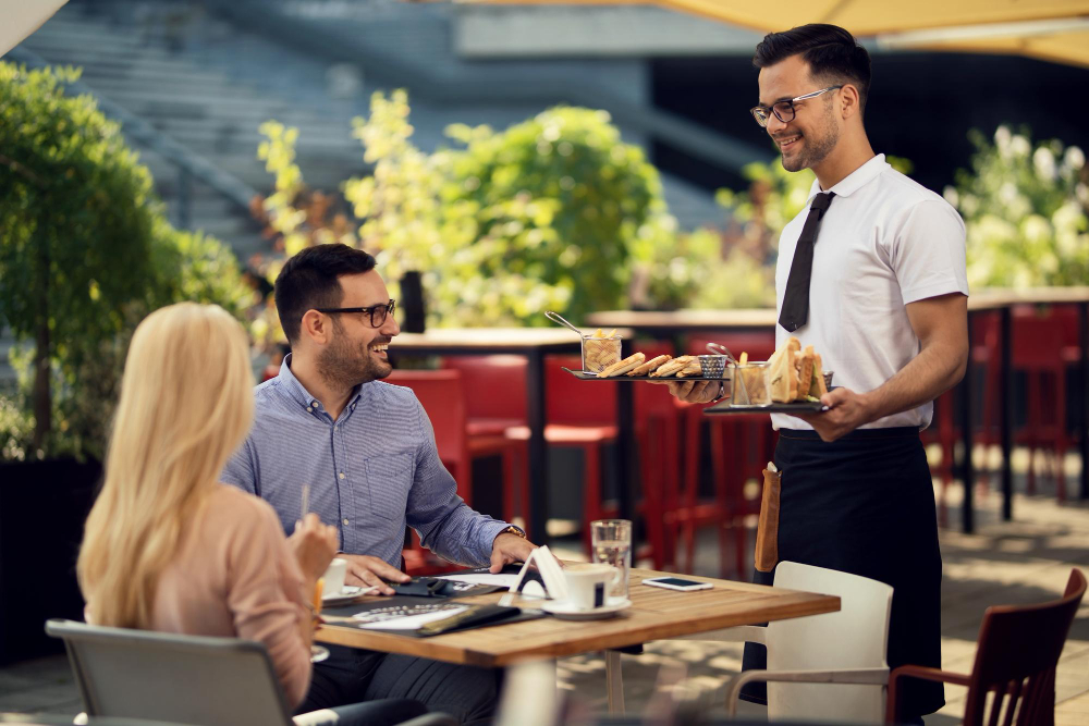 A waiter delivering food to customers