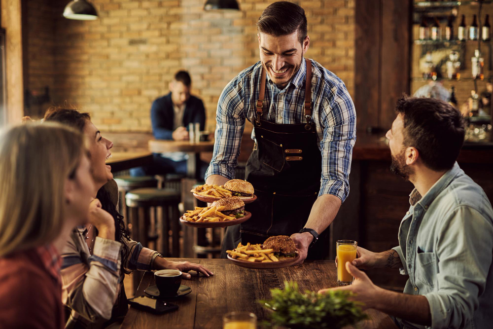 A waiter delivering burgers to customers